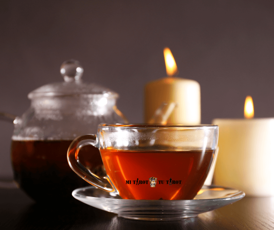 Taza de té transparente junto a velas encendidas dispuesta para una sesión de introspección y crecimiento personal.