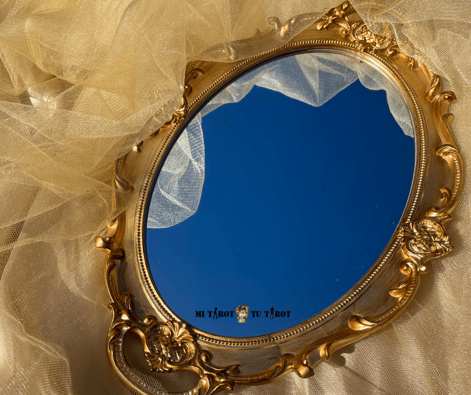 Espejo de mano dorado antiguo reflejando el cielo azul, utilizado como símbolo de claridad mental y conexión espiritual.