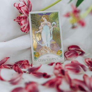 Carta de tarot de La Templanza estilo art nouveau rodeada de pétalos de flores rosas