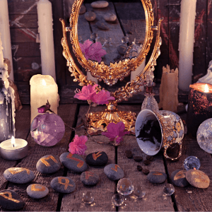 Espejo de marco dorado ornamentado rodeado de velas encendidas, cristales de cuarzo y flores, utilizado en sesiones de introspección personal y análisis de arquetipos.